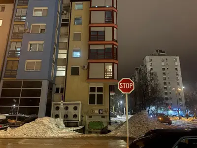 a stop sign in front of a tall building at Stupine Relax Suite TUZLA in Tuzla