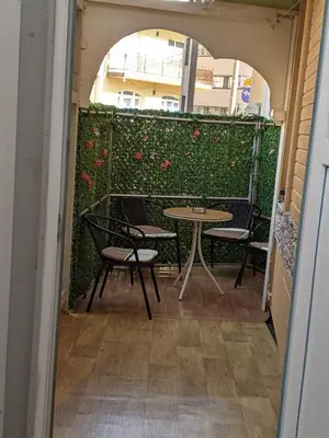 a patio with a table and chairs and flowers at Apartman D Ibukic in Bihać