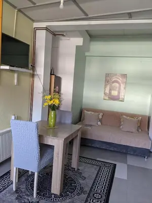 a living room with a table and a couch at Apartman D Ibukic in Bihać
