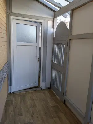 a garage with a white door and a sliding gate at Apartman D Ibukic in Bihać