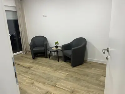 two chairs and a table in a room at Apartmani Vidović in Prozor