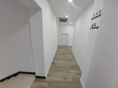 a hallway with white walls and a wooden floor at Apartmani Vidović in Prozor