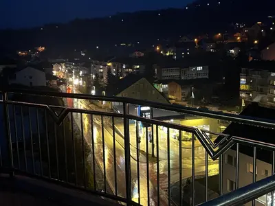 a view of a city at night from a balcony at Apartmani Vidović in Prozor