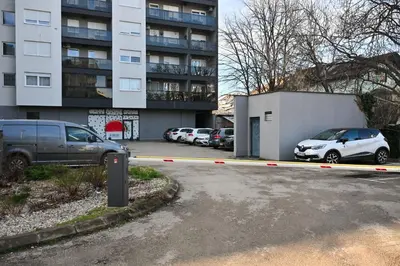 a parking lot with cars parked in front of a building at Apartman Nika in Banja Luka