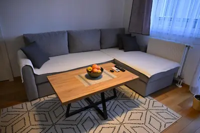a living room with a couch and a table with a bowl of fruit at Apartman Nika in Banja Luka