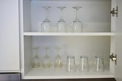 a bunch of glass bottles and glasses on a shelf at Apartman Nika in Banja Luka