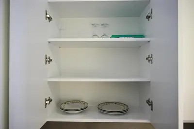 a kitchen with white shelves and two plates at Apartman Nika in Banja Luka