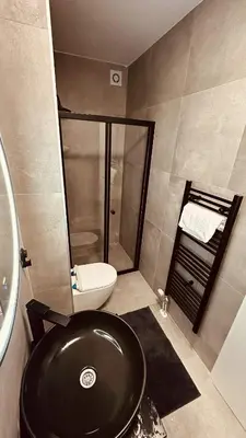 a bathroom with a black sink and a shower at Premium Skver Tuzla - City Center in Tuzla