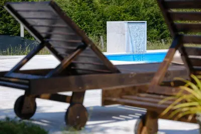 a wooden bench sitting in front of a fountain at Residence Green Pool & SPA in Visoko