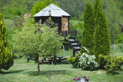 a small wooden playground in a garden with a tree at Residence Green Pool & SPA in Visoko