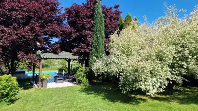 a garden with a gazebo and white flowers at Residence Green Pool & SPA in Visoko