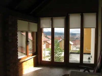 a room with large glass windows with a view at Holiday Home Slavica in Kupres