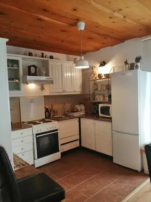 a kitchen with white appliances and a wooden ceiling at Holiday Home Slavica in Kupres