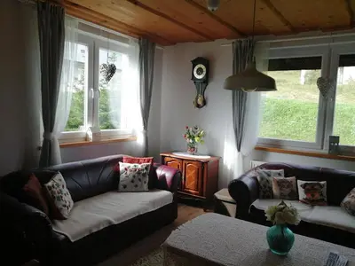 a living room with two couches and two windows at Holiday Home Slavica in Kupres