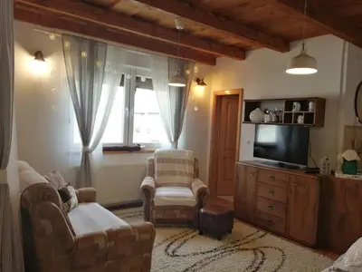 a living room with two chairs and a television at Holiday Home Slavica in Kupres