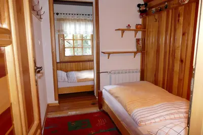 a small room with a small bed and a mirror at Apartman Sani in Vlasic
