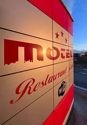 a sign for a restaurant on the side of a building at Motel Papić in Tomislavgrad