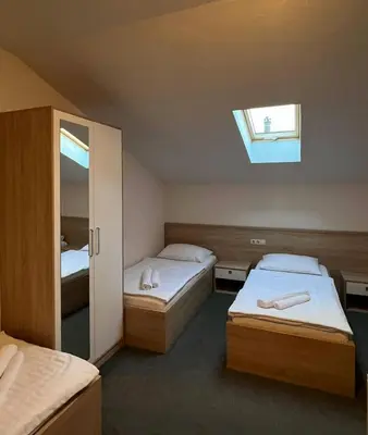 a small bedroom with two beds and a window at Motel Papić in Tomislavgrad