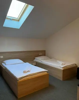two twin beds in a room with a skylight at Motel Papić in Tomislavgrad