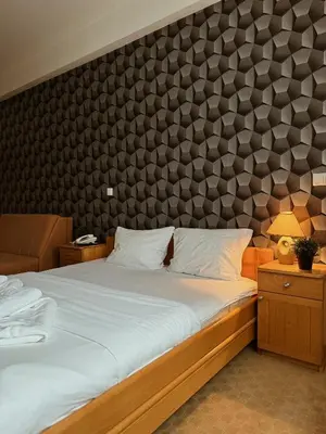 a bedroom with two beds and a large wall at Hotel Kupres in Kupres