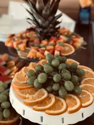 a plate of fruit with grapes and oranges at Hotel Kupres in Kupres