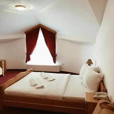 a bedroom with a large bed with a window at Hotel Kupres in Kupres