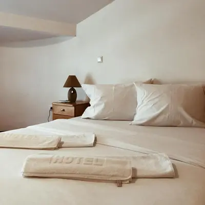 a white bed with two pillows on top of it at Hotel Kupres in Kupres