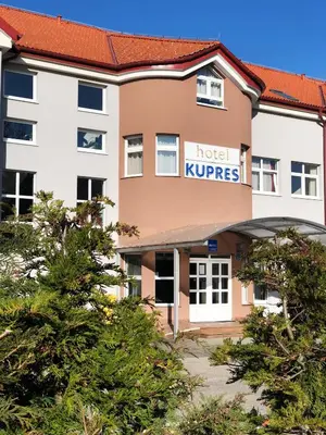 a hotel krups building with trees in the foreground at Hotel Kupres in Kupres
