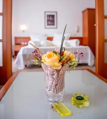 a vase filled with flowers sitting on a table at Hotel Integra in Doboj