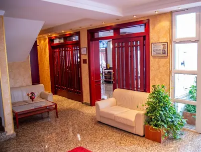 a living room with red doors and a couch at Hotel Integra in Doboj