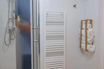 a glass shower door in a bathroom with towels at Piramida Visoko in Visoko