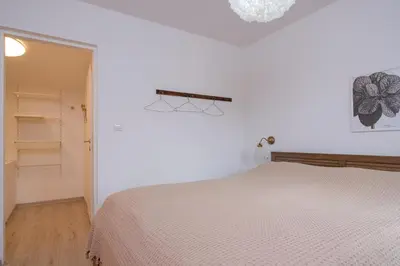 a white bedroom with a bed and a closet at Piramida Visoko in Visoko