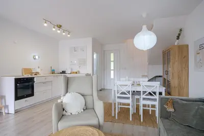 a living room and kitchen with a table and chairs at Piramida Visoko in Visoko