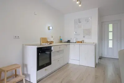 a kitchen with white cabinets and a black appliance at Piramida Visoko in Visoko