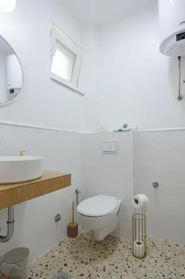 a white bathroom with a toilet and a sink at Piramida Visoko in Visoko