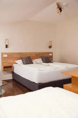 two beds in a hotel room with two beds at Guest House Babilon in Prijedor