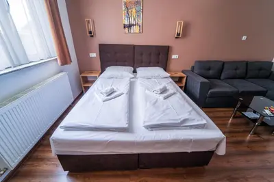 a bedroom with a bed and a couch at Guest House Babilon in Prijedor