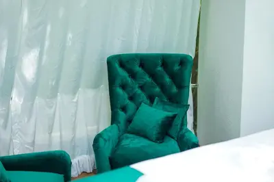 a green chair with two pillows in a room at Japodski otoci in Račić