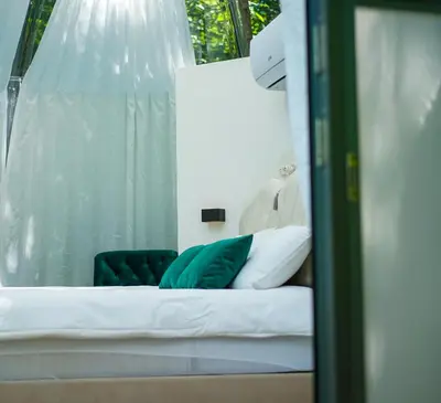 a bed with green pillows and a green chair at Japodski otoci in Račić
