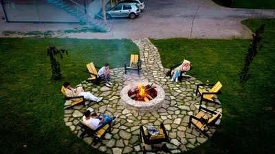 a group of people sitting around a fire pit at Japodski otoci in Račić