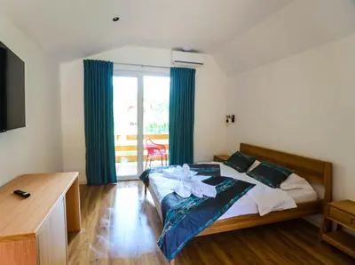 a bedroom with a bed and a large window at Japodski otoci in Račić