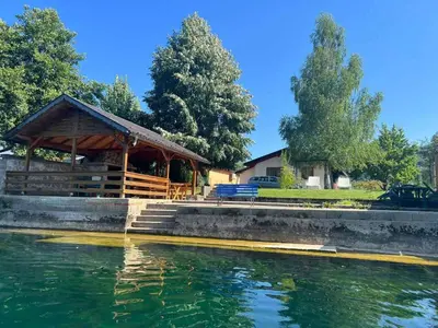 a wooden gazebo next to a body of water at Villa Giulia in Bihać