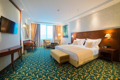 a hotel room with a bed and a desk at Hotel Mellain in Tuzla