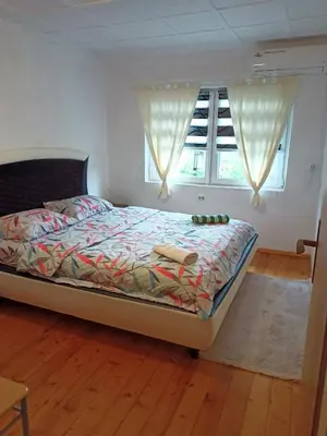 a bedroom with a bed and a window at Home-Vasva and Hazim in Ćukovi