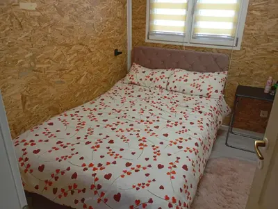 a bed with red flowers on it in a room at Home-Vasva and Hazim in Ćukovi