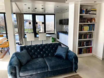a black leather couch in a living room with bookshelves at Villa Una Residence in Bihać