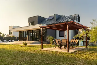 a house with a table and chairs in front of it at Villa Una Residence in Bihać