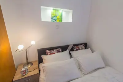 a small bedroom with a bed with white pillows at Stan na Dan Banja Luka in Banja Luka