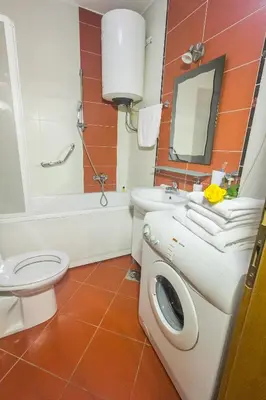 a bathroom with a toilet sink and a washing machine at Stan na Dan Banja Luka in Banja Luka