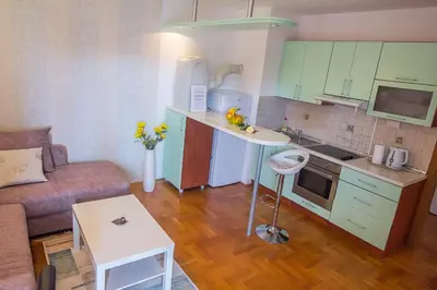 a small kitchen and living room with a couch and a table at Stan na Dan Banja Luka in Banja Luka